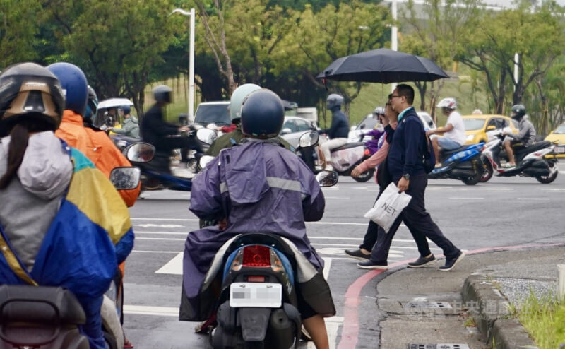 颱風鳳凰接近台灣，高雄市新興區10日午後出現短暫雨勢，民眾撐傘過馬路。中央社記者董俊志攝　114年11月10日