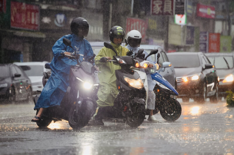 中央氣象署10日發布大雨特報，颱風鳳凰及東北季風影響，北北基宜防局部大雨。圖為大雨中台北市南港區街頭機車騎士。（中央社檔案照片）