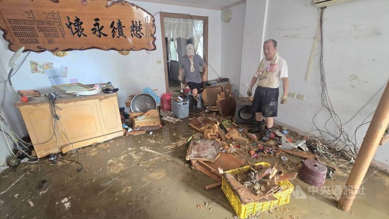 住在蘇澳鎮中原路的林姓男居民(右)在12日積水退後,趕緊與家人整理家園,盼早日恢復正常生活。中央社記者沈如峰宜蘭縣攝 114年11月12日