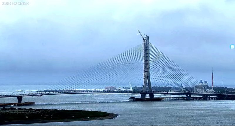 新北市觀光旅遊局於八里左岸設置淡江大橋即時影像，13日將正式啟用，畫面直對淡水河出海口，若天氣好時，淡江大橋與漁人碼頭情人橋襯托淡江夕照的「雙橋拱日」將可一覽無遺。（新北市觀旅局提供）中央社記者黃旭昇新北市傳真　114年11月12日