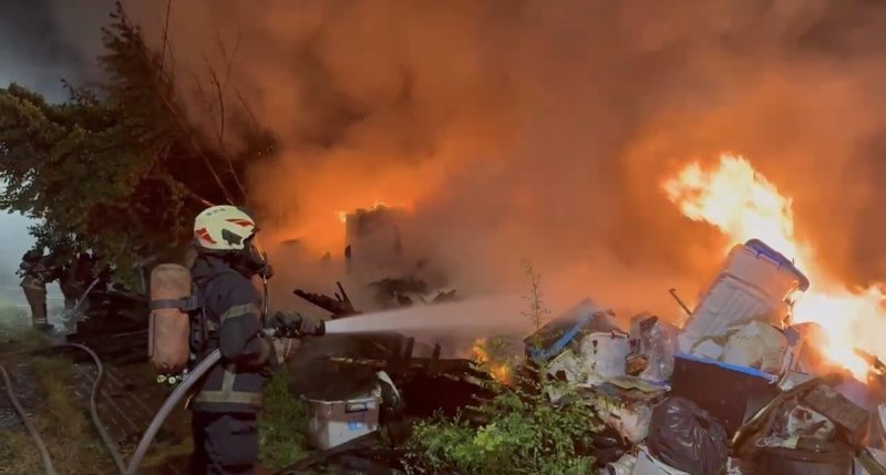 台南市安南區民宅13日凌晨發生火警，且波及隔壁住戶，屋內蔡姓男子燒燙傷逃出送醫，消防人員緊急灌救撲滅火勢。（台南市消防局提供）中央社記者張榮祥台南傳真　114年11月13日