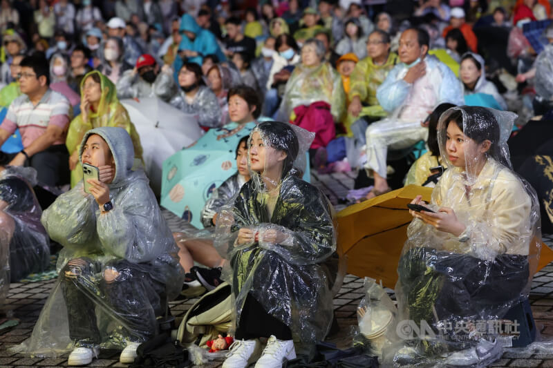 柏林愛樂戶外同步轉播活動13日晚間登場，天公不作美，民眾穿著雨衣齊聚兩廳院藝文廣場，欣賞動人樂音。中央社記者吳家昇攝　114年11月13日
