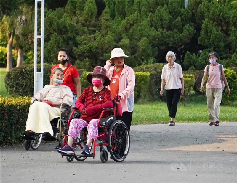 圖為家庭看護移工推著長者散步。（中央社檔案照片）