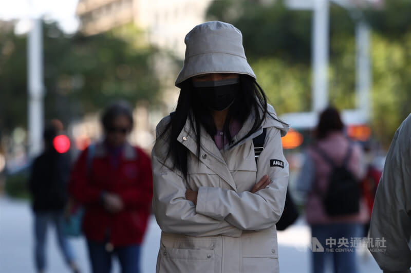 圖為新北市街頭民眾穿著禦寒衣物。（中央社檔案照片）