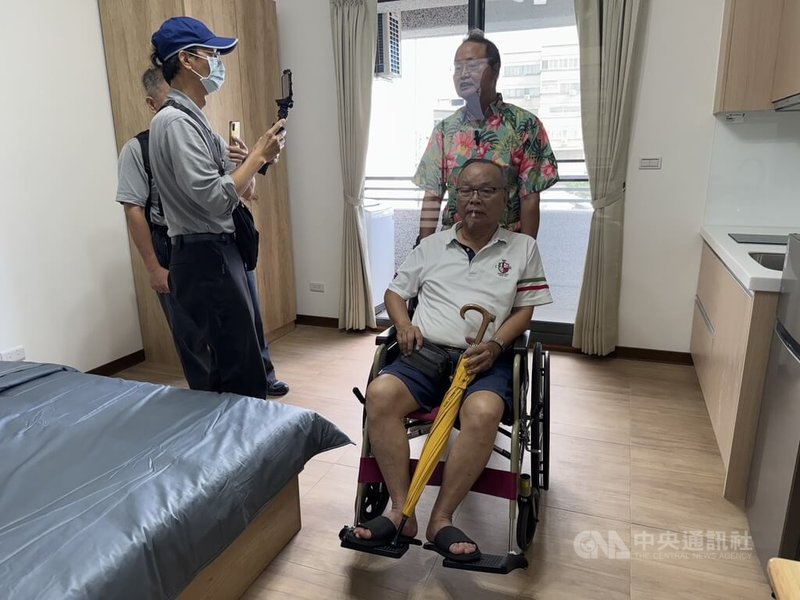 花蓮0403地震中繼宅「大愛福利社區大樓」15日落成揭牌,北濱街受災戶吳永和(前右)坐著輪椅,由弟弟推著他到場參與並參觀房屋,吳永和說,未來盼能趕快重建家園。中央社記者張祈攝 114年11月15日