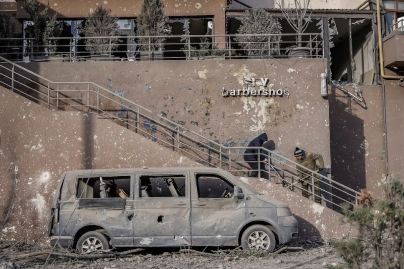 烏克蘭首都基輔住宅大樓14日遭俄羅斯空襲，居民清理瓦礫。（路透社）