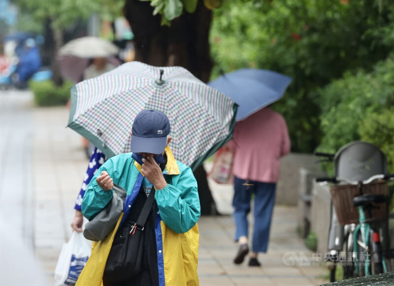 圖為台北市萬華區民眾穿雨衣、撐傘擋雨。（中央社檔案照片）