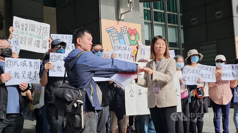 瓦城泰統集團位於中和的工廠將搬遷中壢,多名員工質疑距離過遠且資遣費審查標準未公開透明,17日到新北市政府陳情,勞工局代理科長蕭慧敏(前右)接下陳情書。中央社記者王鴻國攝 114年11月17日