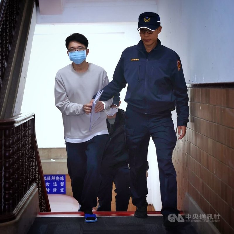 空軍飛指部少校管制官邱翰林（左）涉共諜案遭訴，移審台灣高等法院，18日晚間高院開接押庭訊問，邱翰林由法警提解到庭。中央社記者王飛華攝　114年11月18日