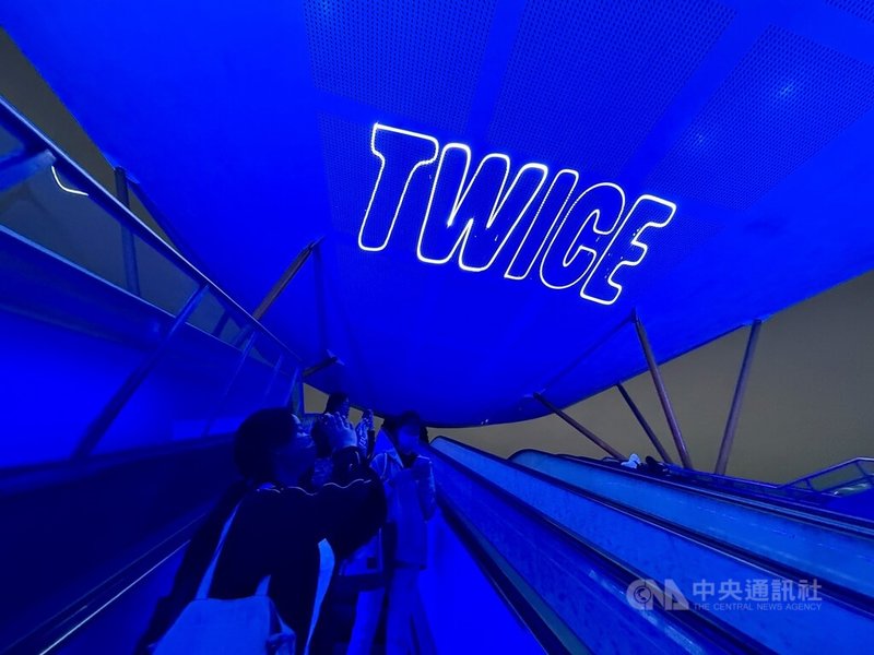 韓國女團TWICE將於22、23日在高雄國家體育場開唱，18日晚間民眾在中央公園捷運站1號出口處景點，拍下亮起「藍燈」應援。中央社記者董俊志攝　114年11月18日