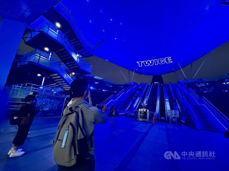 韓國女團TWICE將於22、23日在高雄國家體育場開唱，18日晚間中央公園捷運站1號出口上演燈光文字秀，民眾也紛紛拿起手機拍攝。中央社記者董俊志攝　114年11月18日