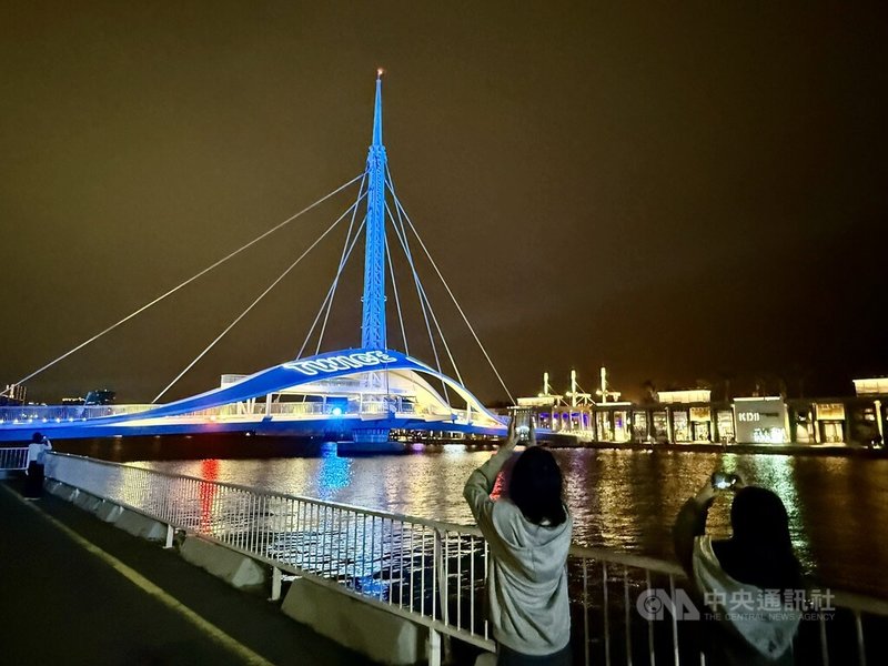 韓國女團TWICE將在高雄國家體育場開唱，知名景點大港橋18日晚間點起藍燈和雷射字體，慶祝TWICE到來。中央社記者董俊志攝 114年11月18日