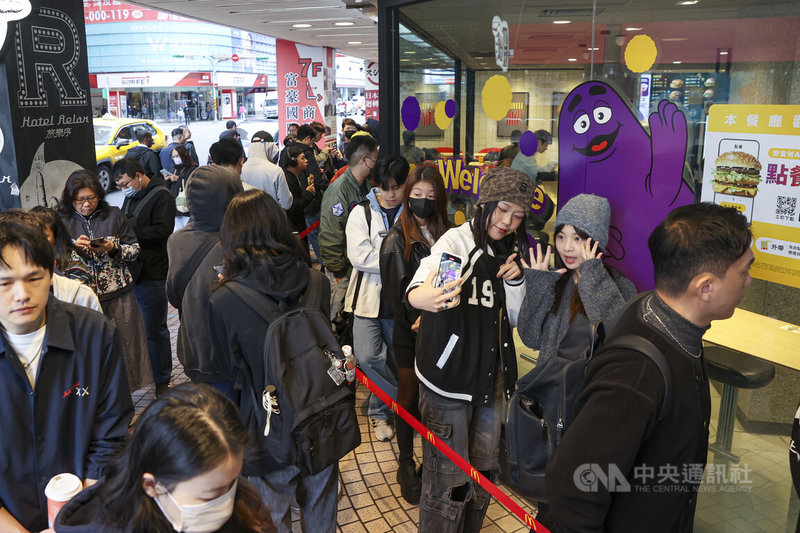 速食業者麥當勞宣布在全台12間指定餐廳限量販售「麥當勞奶昔」，許多民眾為了重溫經典味道前往搶購，台北市一間麥當勞餐廳19日上午出現購買奶昔人潮，有民眾排隊時開心自拍。中央社記者鄭清元攝　114年11月19日
