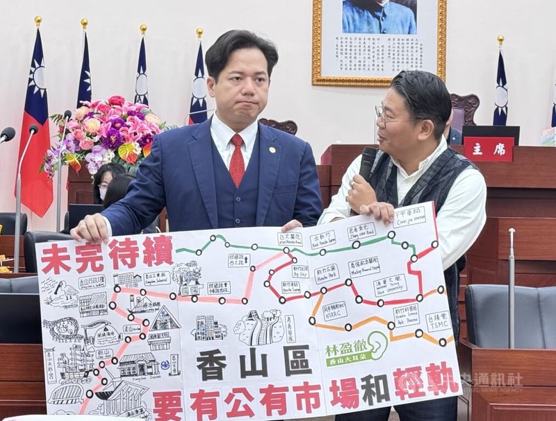 民進黨新竹市議員林盈徹（右）20日在議會總質詢時，將手繪的「香山版」輕軌地圖贈給代理市長邱臣遠（左），盼市府能將新竹輕軌延伸至香山區。中央社記者魯鋼駿攝 114年11月20日