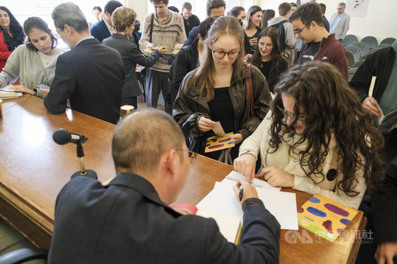 台灣作家黃崇凱的小說「新寶島」西文譯本首場新書講座,19日在馬德里康普頓斯大學文學院舉辦,活動結束後學生們熱烈購書,排隊簽書。中央社記者胡家綺馬德里攝 114年11月20日