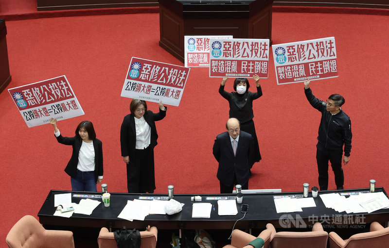 立法院會21日下午針對攸關公投綁大選的公投法第23條修正草案進行投票表決，民進黨立法院黨團在議場高舉標語表達反對立場。前為民進黨立院黨團總召柯建銘。中央社記者趙世勳攝　114年11月21日