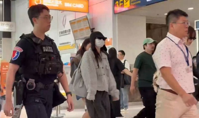 韓國女團TWICE將在高雄國家體育場開唱，成員21日下午抵台，吸引許多粉絲到高雄機場接機，航警協助現場維安勤務。（讀者提供）中央社記者林巧璉傳真　114年11月21日