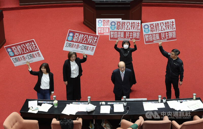 立法院會21日下午針對攸關公投綁大選的公投法第23條修正草案進行投票表決，民進黨立法院黨團在議場高舉標語表達反對立場。前為民進黨立院黨團總召柯建銘。中央社記者趙世勳攝　114年11月21日