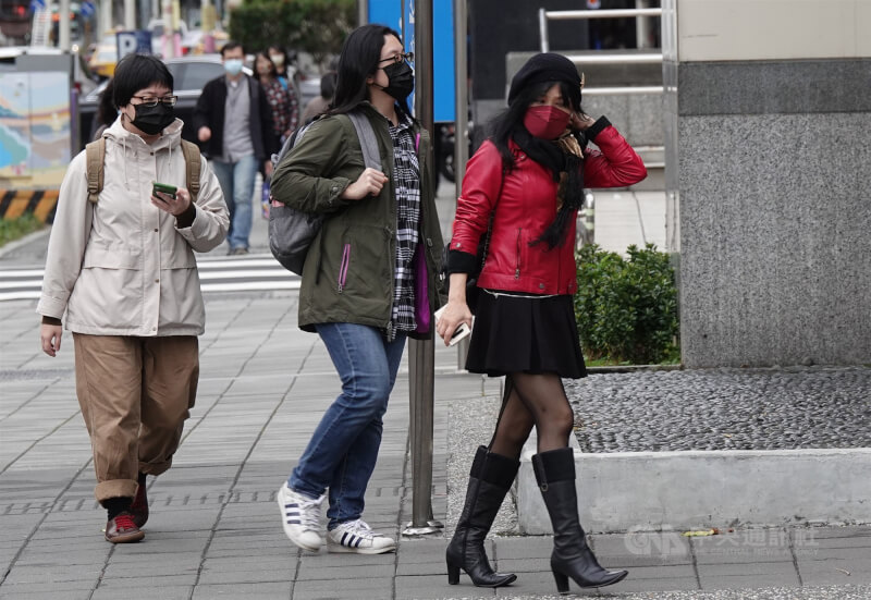 氣象專家吳德榮表示，21日早晨冷空氣略減弱，氣溫比昨晨回升，北部約17至24度。圖為北市街頭民眾穿著外套圍巾禦寒。（中央社檔案照片）