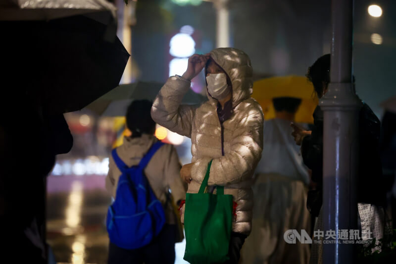 圖為新北市街頭民眾穿上羽絨外套禦寒。（中央社檔案照片）