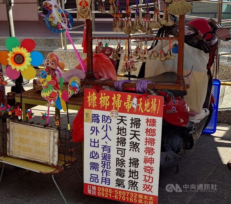 許秋月創新製作傳統槺榔小掃帚，在朴子配天宮前擺攤販售。中央社記者蔡智明攝　114年11月23日