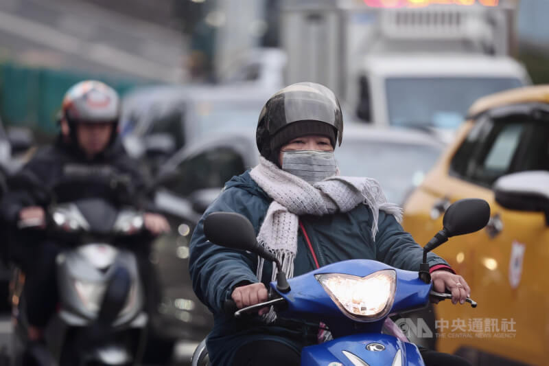 圖為寒風中的台北市松山區街頭機車騎士。（中央社檔案照片）