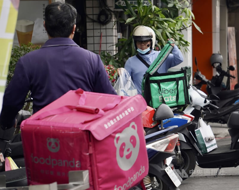 圖外送員在高雄市鳳山區路邊臨停接單，準備送餐。（中央社檔案照片）