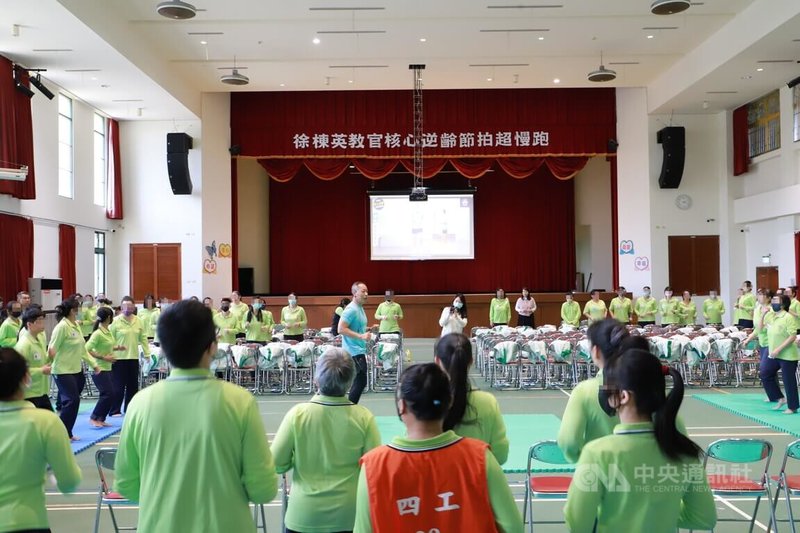 台中女子監獄27日邀請推廣超慢跑運動的教官徐棟英(中淺藍衣者)到場帶領收容人學習動作及要領,未來也將持續推廣適合監所環境的運動。中央社記者蘇木春攝 114年11月27日