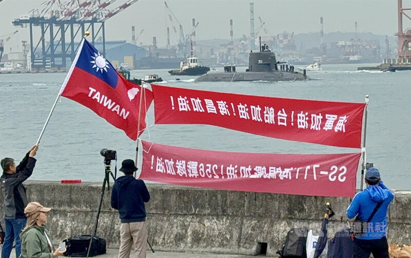 國造潛艦海鯤號27日上午進行第4次出海測試(SAT),軍事迷一早就聚集在高雄港,拉著紅色布條加油打氣。中央社記者董俊志攝 114年11月27日