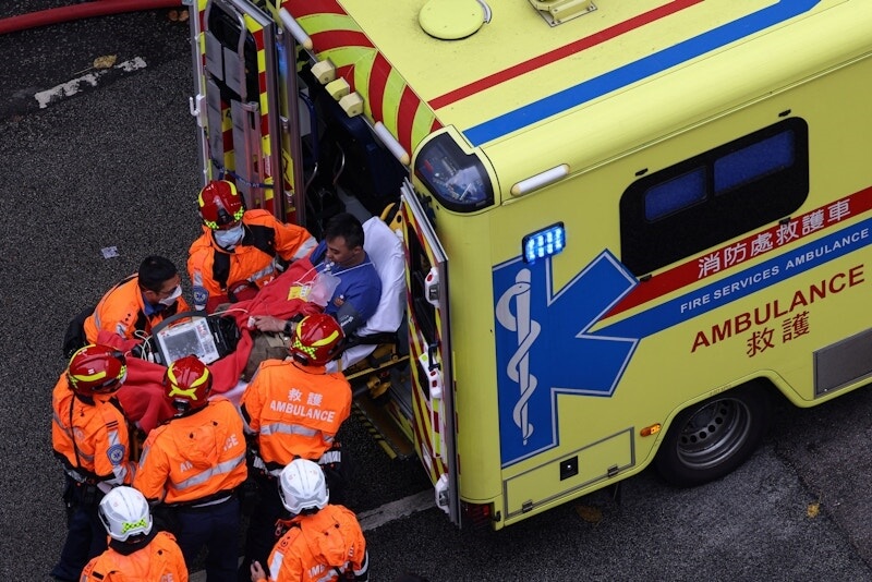 27日一名受傷的消防員被送上救護車。(路透社)