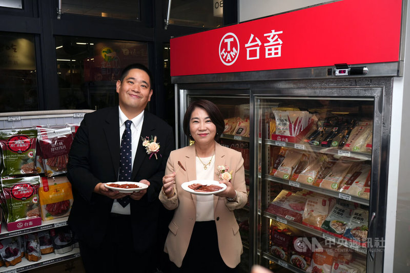 台灣農畜產工業股份有限公司28日在屏東西市場啟用新據點,「台畜門市」販售豬肉加工品,台畜董事長張華欣(左)介紹品項,屏東縣長周春米(右)試吃,稱讚即食產品方便又美味。中央社記者黃郁菁攝 114年11月28日