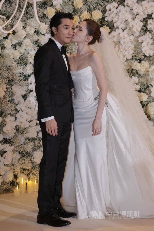 藝人許瑋甯(右)、邱澤(左)結婚近4年後,28日晚間在台北文華東方酒店補辦婚宴,兩人在開宴前甜蜜現身受訪,應媒體要求親吻臉頰,現場幸福氛圍洋溢。中央社記者裴禛攝 114年11月28日