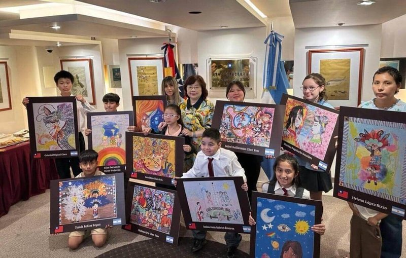 駐阿根廷代表謝妙宏（後排左4，著黃色上衣）頒發獎座給予中華民國第56屆世界兒童畫展阿根廷得獎者，其中兩名台僑學子連年獲獎，表現亮眼。（駐阿根廷代表處提供）中央社記者黃韻如布宜諾斯艾利斯傳真 114年11月29日