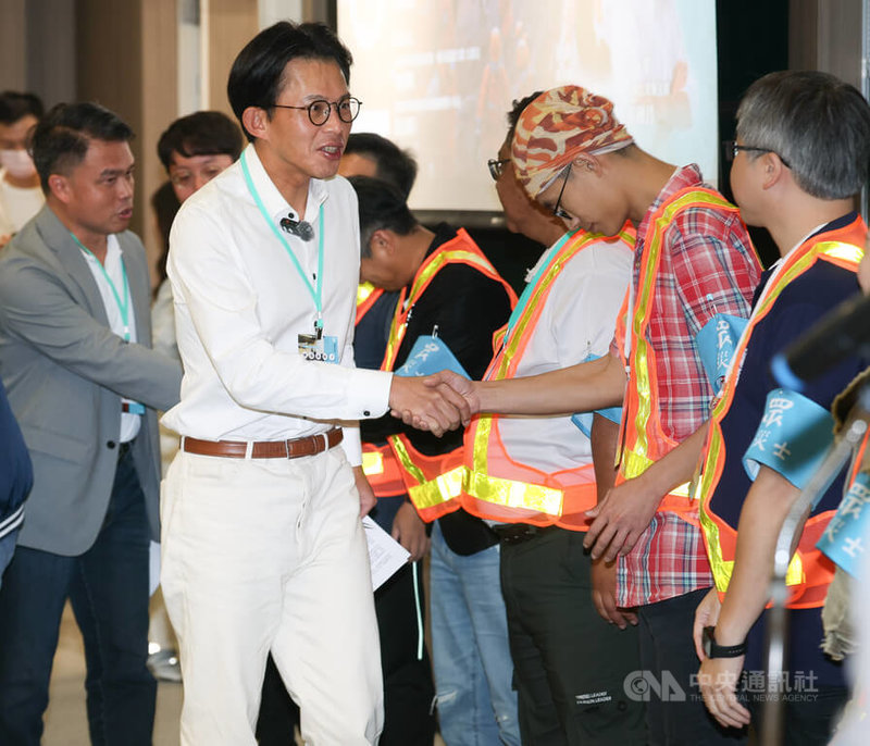 台灣民眾黨主席黃國昌（前左）29日下午在台北出席由黨內主辦的「極端氣候下跨域整備與韌性強化」系列論壇，並和與會防災士握手致意。中央社記者謝佳璋攝　114年11月29日