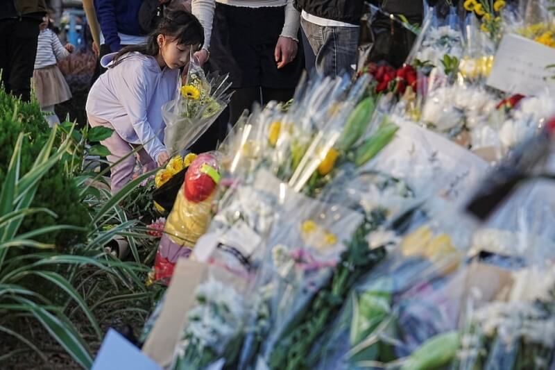 一位女孩29日在宏福苑附近的臨時紀念碑前獻花。（路透社)