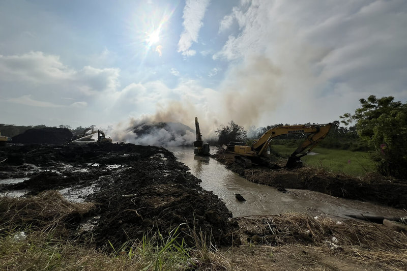 台南市後壁區烏樹林廢棄物暫置場11月21日起火，仍有部分悶燒情況，環保局指出，1日以挖土機利用地形與已燃盡樹枝構築圍堰，並自嘉南大圳引入水源，透過由底層滲水浸泡方式，提升降溫效率。（台南市政府提供）中央社記者楊思瑞台南傳真　114年12月1日