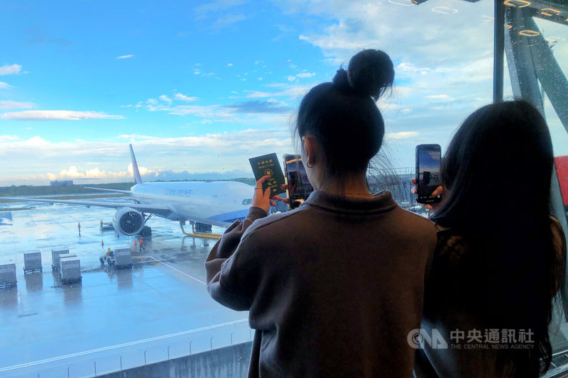 桃園國際機場第3航廈北登機廊廳1日試營運，機場公司表示，試營運首日安排中華CI130、長榮BR116及星宇JX741共3家國籍航空約968名旅客，飛往日本札幌及泰國曼谷，候機旅客利用等待時間在大片玻璃帷幕前拍照。中央社記者吳睿騏桃園機場攝　114年12月1日