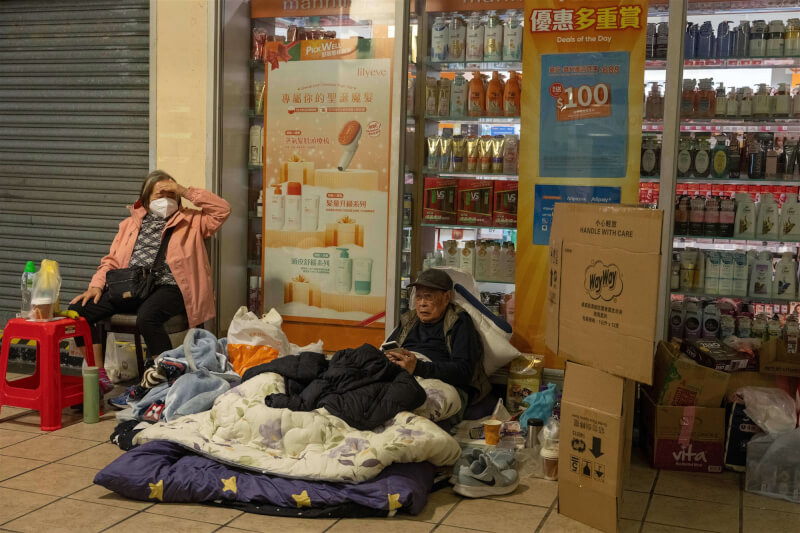居住在香港宏福苑大樓的老年居民在火災發生後前往附近一家購物中心避難。（美聯社）