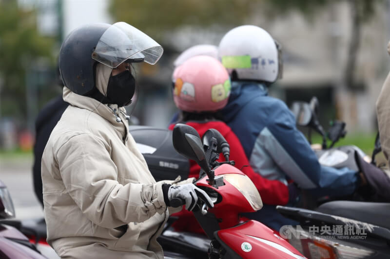 氣象專家吳德榮表示，4、5日清晨北台灣平地最低溫約降至攝氏12度。圖為新北市土城區機車騎士做好保暖措施。（中央社檔案照片）