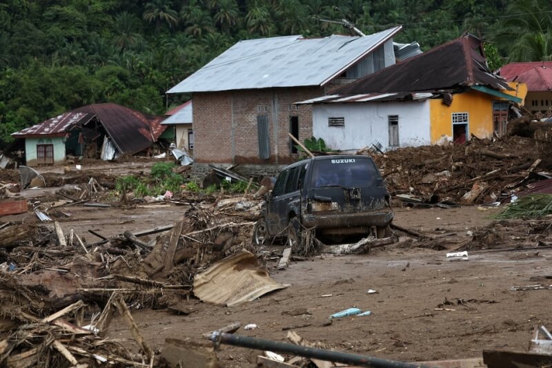 季風豪雨跟兩個熱帶氣旋侵襲南亞後，印尼西蘇門答臘省一處村庄的汽車仍陷在泥濘中。（路透社）