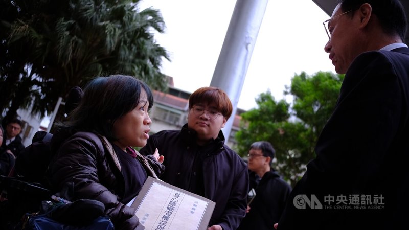 台灣身心障礙者自立生活聯盟等30多個身障團體3日前往衛生福利部陳情，衛福部長石崇良（右）親自出面，接下陳情資料。中央社記者曾以寧攝 114年12月3日