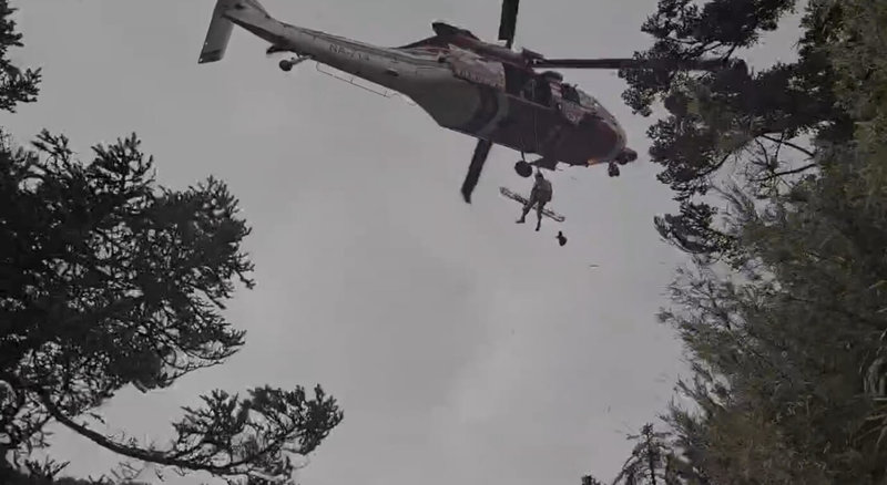 新北市郭姓退休校長日前攀登玉山後四峰失聯，1日被路過山友發現躺臥邊坡已明顯死亡。空勤總隊3日上午把握時機出動直升機協助吊掛遺體，後續交由家屬及員警處理。（高雄市消防局提供）中央社記者洪學廣傳真　114年12月3日