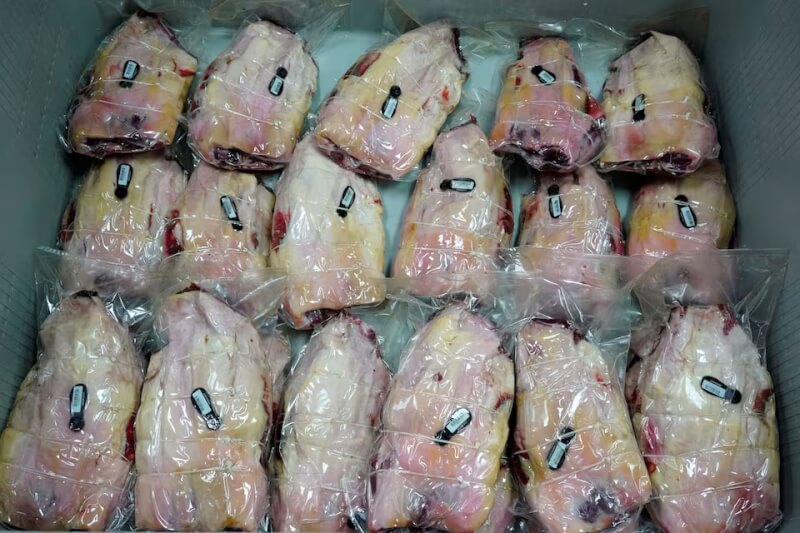 圖為西班牙一間工廠正將火腿真空包裝。（路透社）