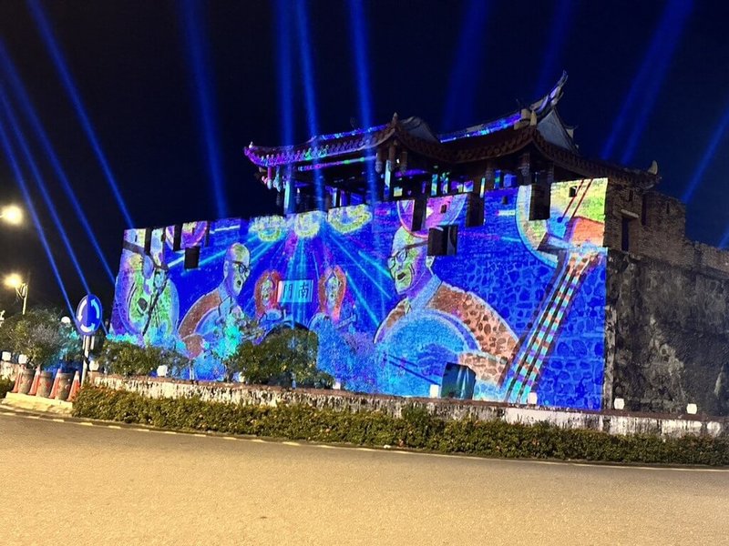 屏東縣政府以光影藝術點亮古城歷史風華,南門在夜晚華麗變身為時光舞台,跨域音樂搭配大型光雕投影,訴說恆春半島歷史軌跡。(屏東縣政府文化處提供)中央社記者黃郁菁傳真 114年12月5日
