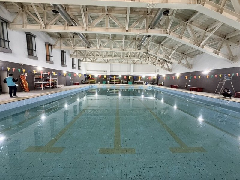 國立新港藝術高中游泳池因地震造成地面裂痕及漏水問題已閒置2年，天花板落漆更影響水質與安全，民進黨立委蔡易餘爭取教育部編列預算修復。（蔡易餘提供）中央社記者蔡智明傳真　114年12月5日