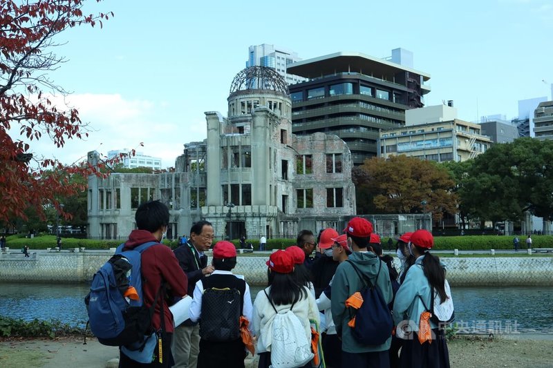 小學生在原爆圓頂館外聚集，聆聽導覽員講解，攝於11月21日。中央社記者謝怡璇廣島攝　114年12月5日