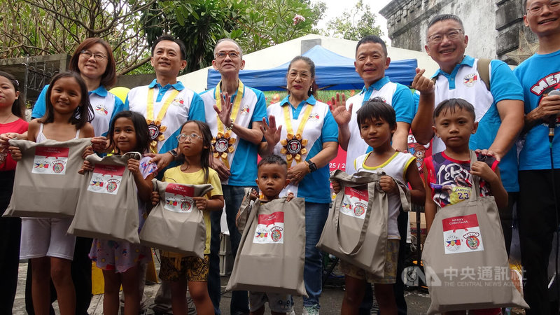 在「大都會國際兒童事工」牽線下，菲律賓台灣工商總會理事主席林家丞（後左2）、會長楊鴻裕（後左3），5日偕同幹部前往馬尼拉北部公墓，為300多名小朋友發送食品包。中央社記者林行健馬尼拉攝　114年12月5日