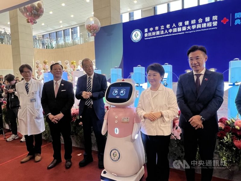 台中市政府委託中國醫藥大學營運的台中市立老人復健綜合醫院6日開幕，台中市長盧秀燕（右2）與AI照護機器人「愛寶」互動。中央社記者郝雪卿攝  114年12月6日