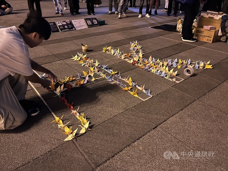 在台港人組成香港宏福苑火災台灣悼念關注組，6日晚在中正紀念堂自由廣場舉辦悼念晚會，現場用民眾手折紙鶴填滿「HK」字樣。中央社記者李雅雯攝 114年12月6日