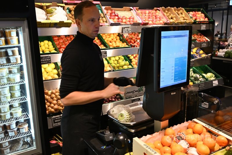 在荷蘭阿姆斯特丹舉行台南芭樂的首賣會吸引大批民眾，店員忙著替購買芭樂的消費者結帳。中央社記者吳柏緯阿姆斯特丹攝　114年12月6日